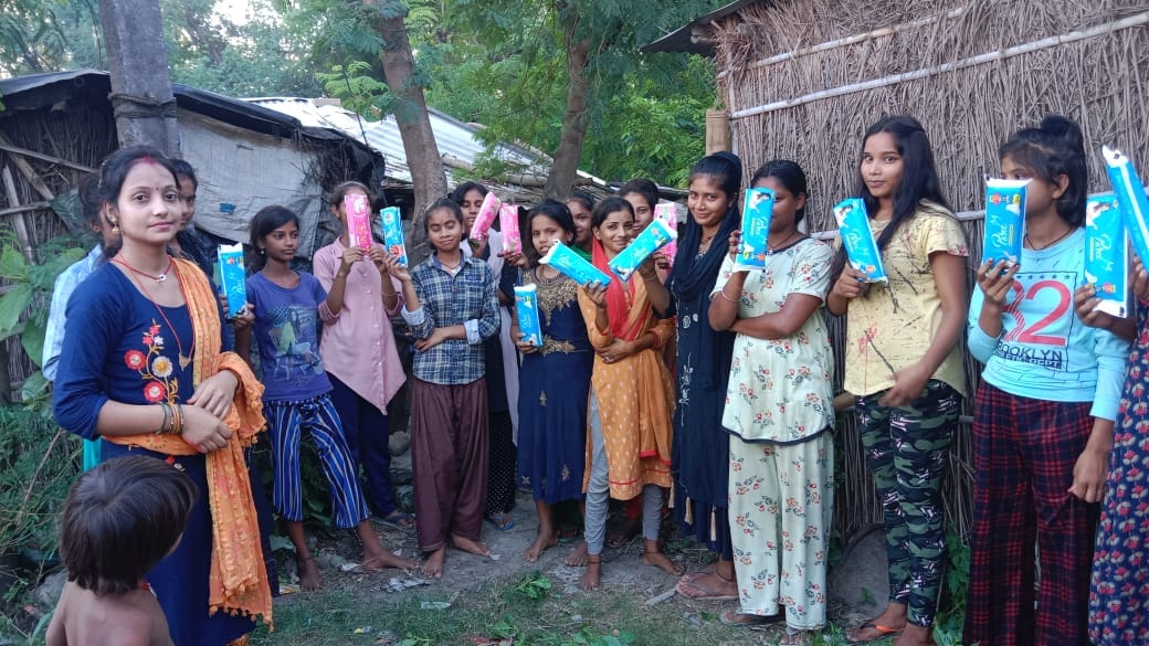 Jaymala - INDA 2022 pads Young women in an East Indian village holding packages of reusable sanitary napkins.