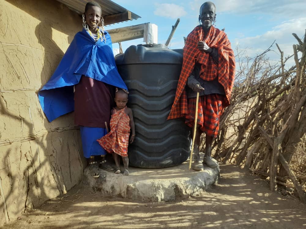 Maasai mother, father, and small daughter with new 1,000-liter water tank